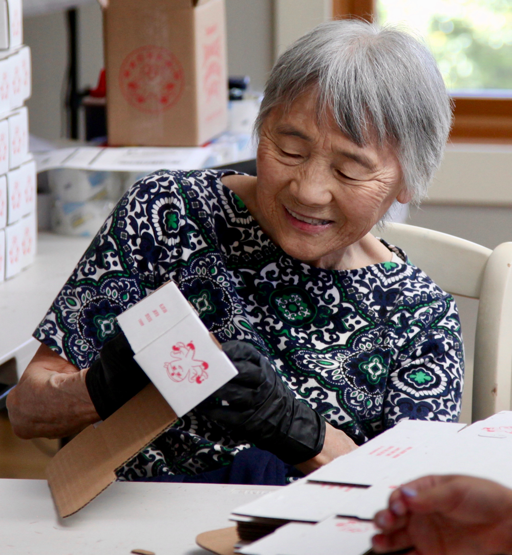 Judy Yokoyama packing bottles of the family sauce